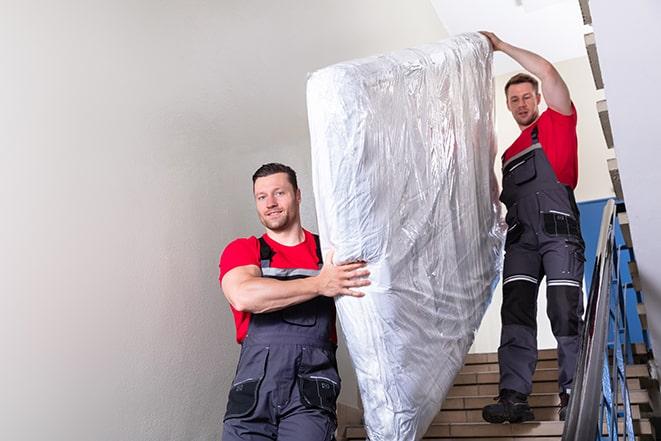 heavy lifting as a box spring is carried out of a house in Franconia, VA